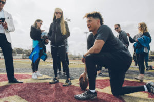 1UP Sports Marketing client Patrick Mahomes kneels next to Brittney Lynne Matthews and others during a video shoot