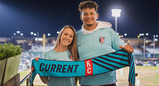 1UP Sports Marketing clients Patrick and Brittany Mahomes hold a KC Current banner together