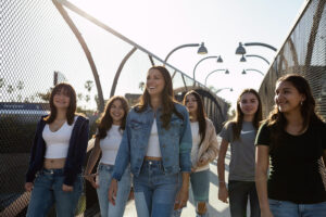 Alex Morgan walking down a street surrounded by young girls