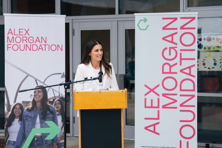 1UP Sports Marketing client Alex Morgan speaking at a podium at her Alex Morgan Foundation launch event