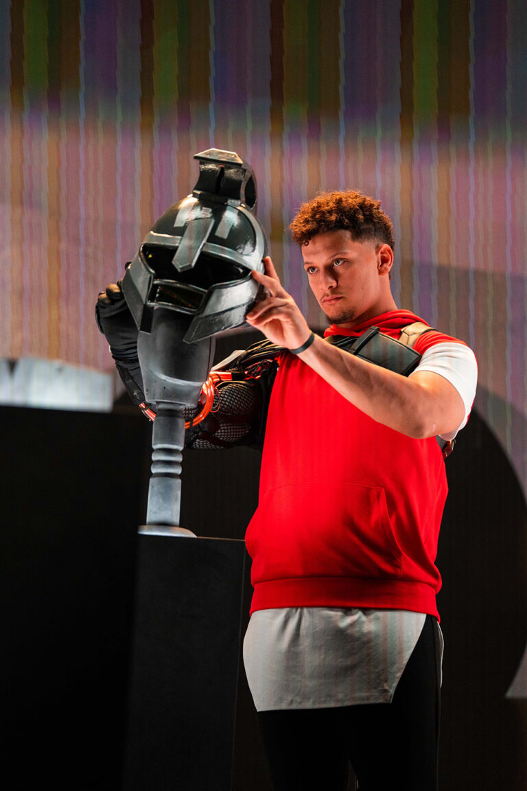 1UP client Patrick Mahomes looks at a stylized Trojan helmet for his partnership with Fortnite.