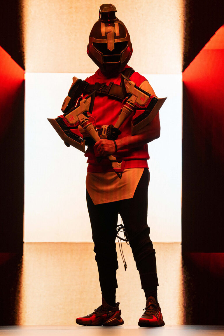 1UP client Patrick Mahomes holds a stylized axe weapon and wears a Trojan helmet and body armor for his partnership with Fortnite.