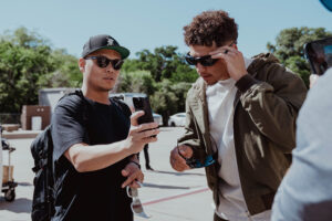 1UP Sports Marketing client Patrick Mahomes lifting his Oakley sunglasses to look at someone's phone