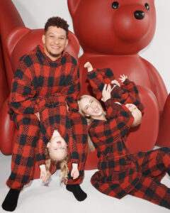 1UP Sports Marketing clients Patrick and Brittany Mahomes pose with kids in red checked onesies by SKIMS